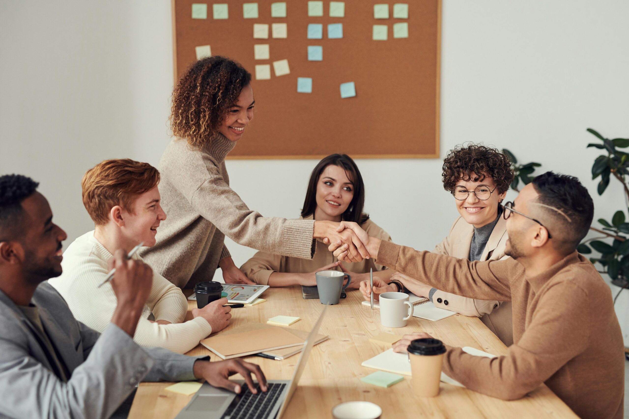 Group of coworkers shaking hands during a meeting at a modern office table