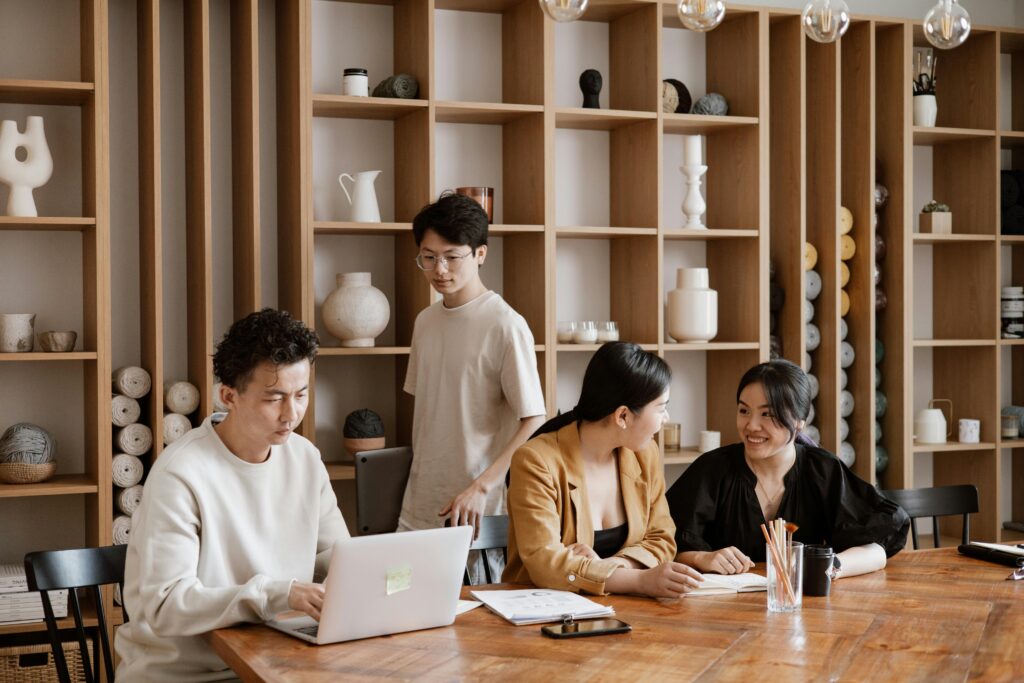 Spacious office with colleagues working, discussing, and walking around a large table