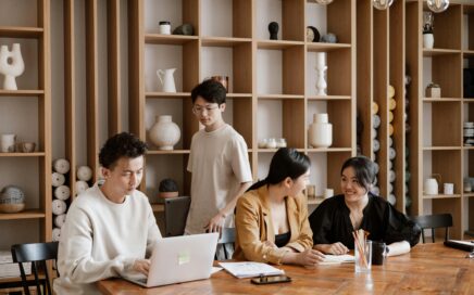Spacious office with colleagues working, discussing, and walking around a large table