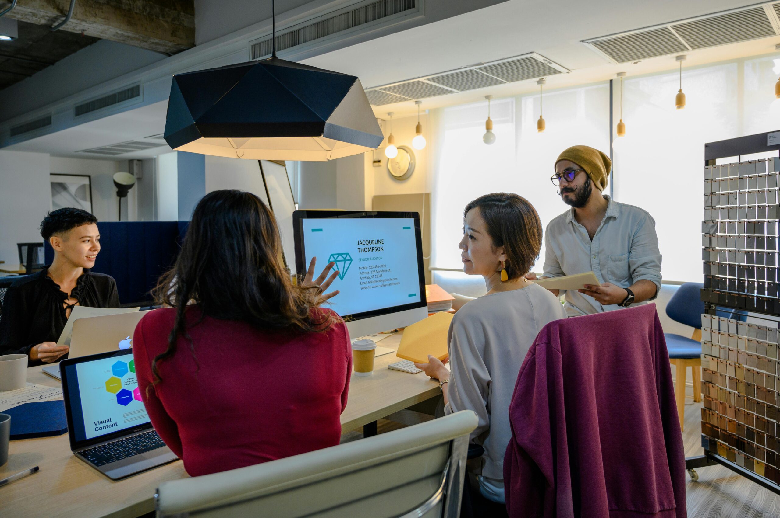Colleagues brainstorming in a modern office setting with laptops and visual charts on the table