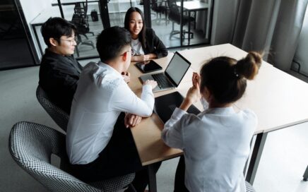 Business team working together around a table with laptops, documents, and open discussions