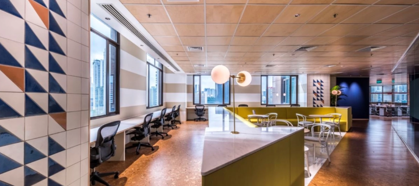 Modern coworking space with geometric wall design and comfortable seating areas.