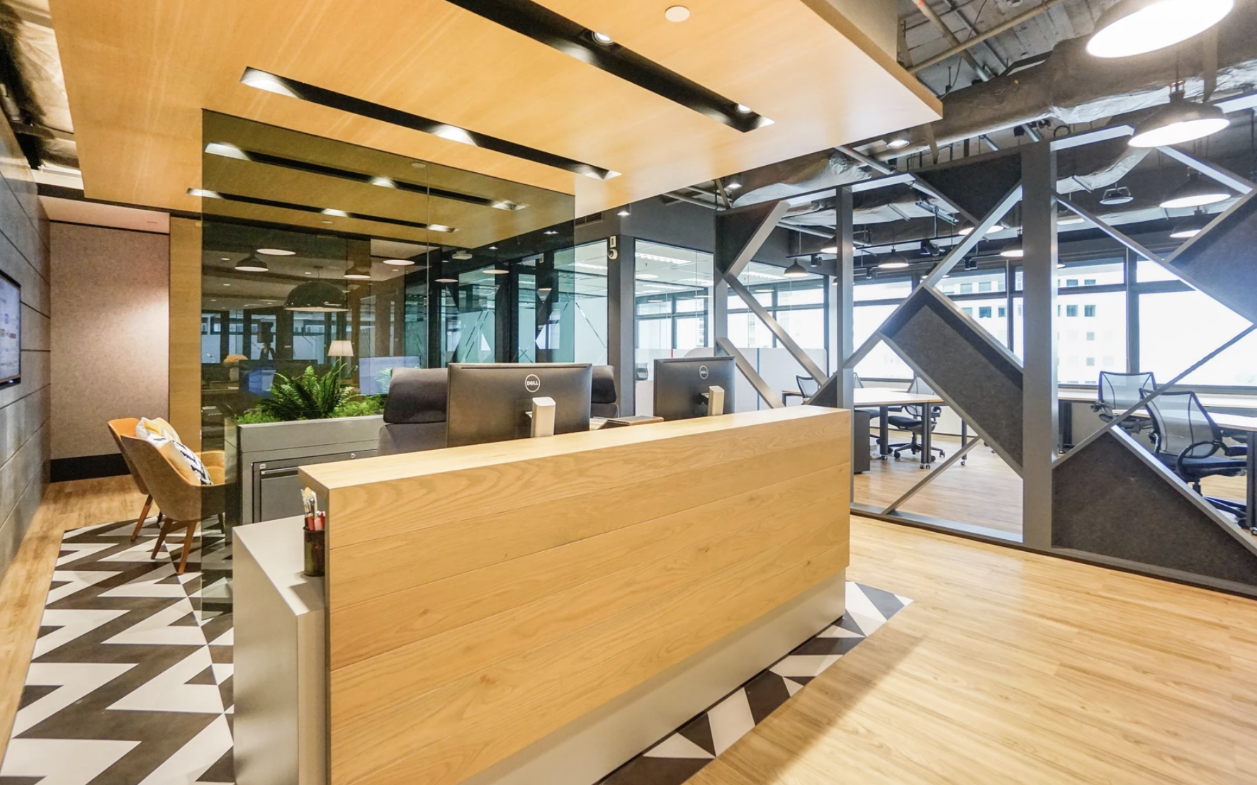 Modern coworking office reception with wooden design, open layout, and stylish black metal partitions